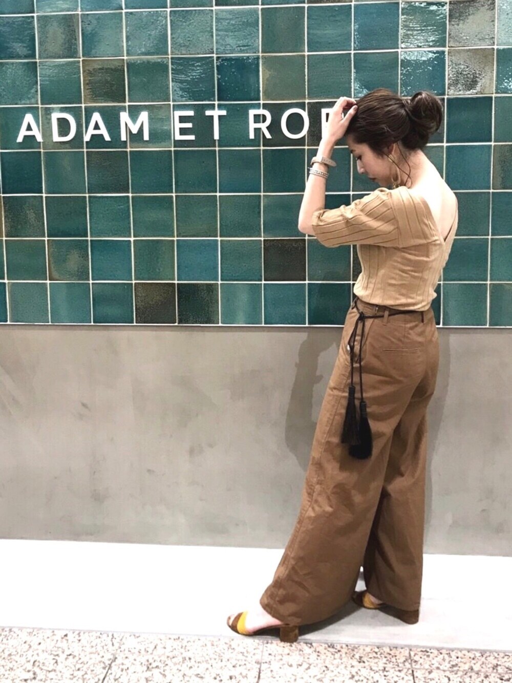 ブラウン系のその他パンツ、ブラウン系のTシャツ/カットソー、イエロー系のサンダルを着用したレディースの春コーディネートの1枚目の写真