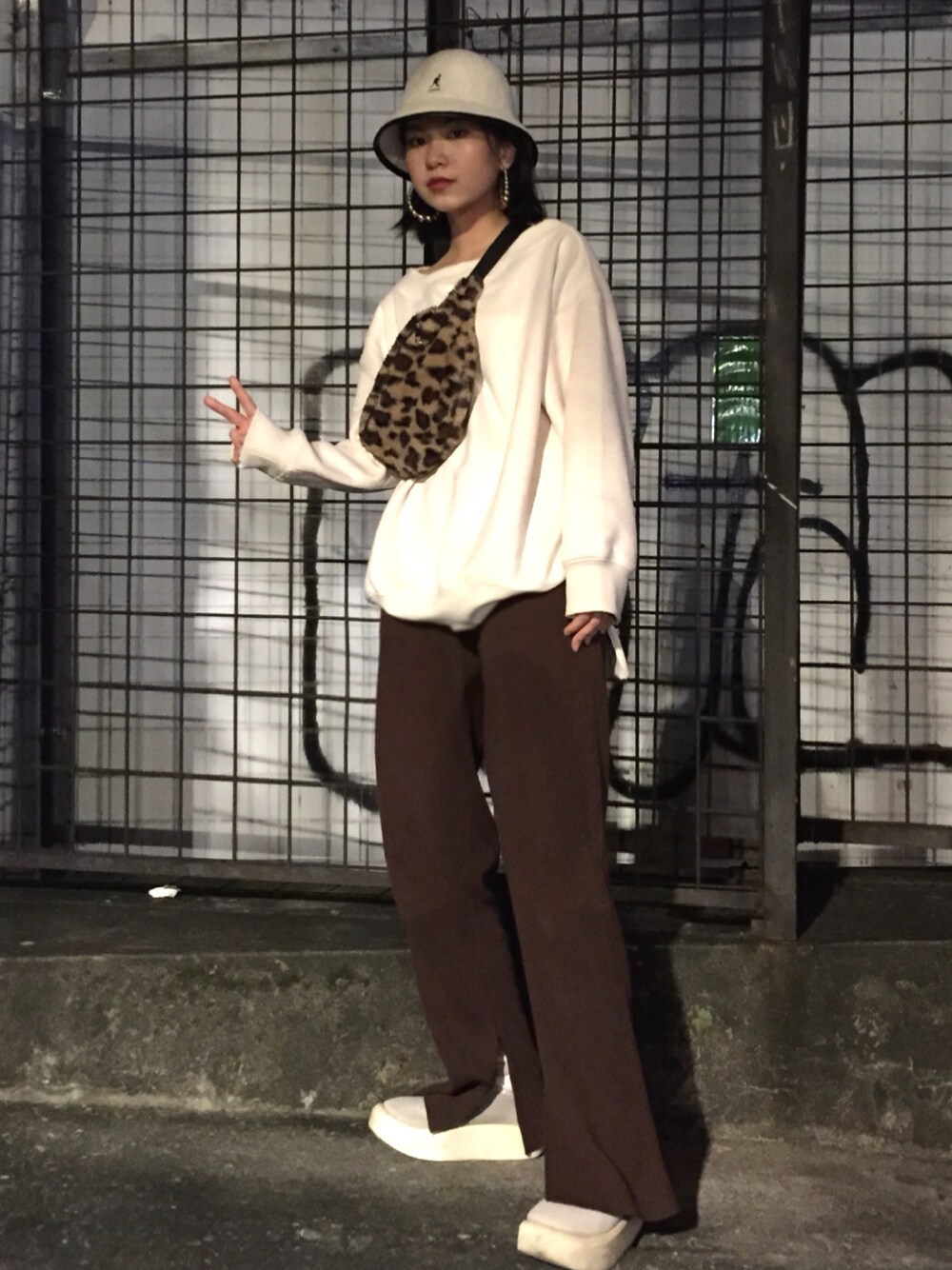 ブラウン系のボディバッグ/ウエストポーチ、ホワイト系のその他トップス、ブラウン系のチノパンツを着用したレディースの秋コーディネートの1枚目の写真