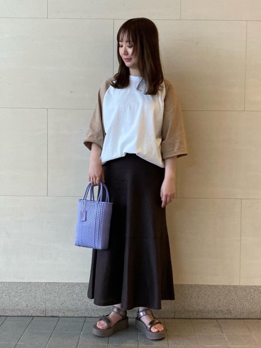 ブラウン系のサンダル、パープル系のかごバッグ、ブラウン系のスカートを着用したレディースの夏コーディネートの1枚目の写真