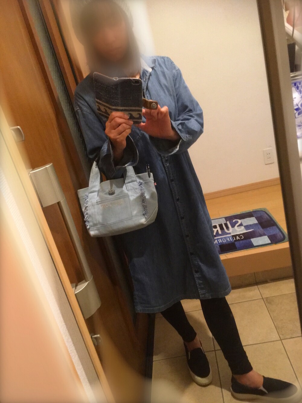 ブルー系のトートバッグ、ブルー系のシャツワンピース、ブラック系のスリッポンを着用したレディースの春コーディネートの1枚目の写真