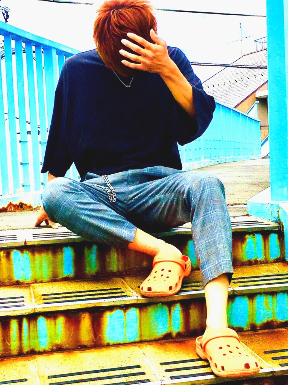 ブラック系のTシャツ/カットソー、グレー系のスラックス、オレンジ系のサンダルを着用したメンズの夏コーディネートの1枚目の写真