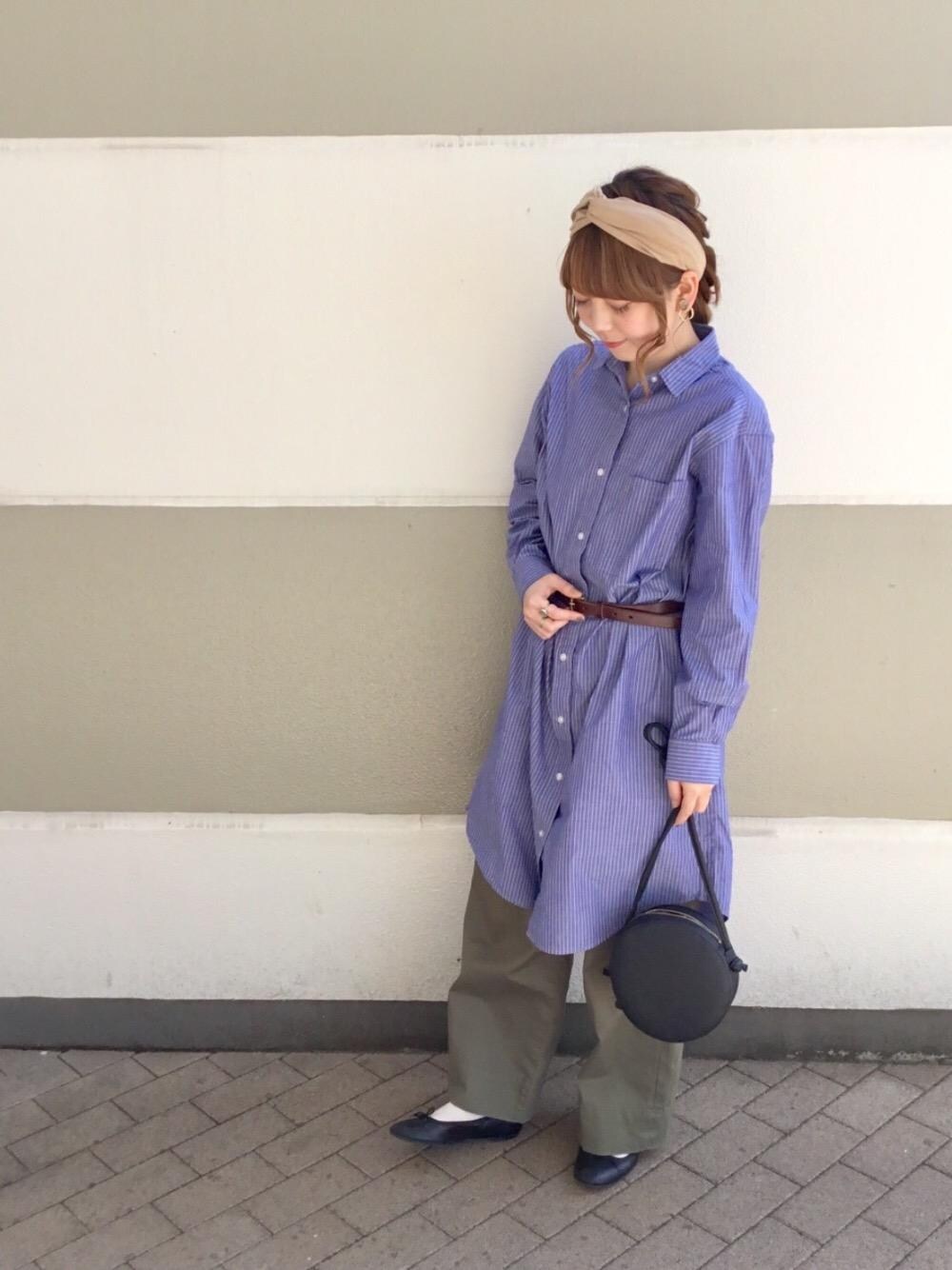 ブルー系のシャツワンピース、ブラック系のバレエシューズ、ブラック系のショルダーバッグを着用したレディースの春コーディネートの1枚目の写真