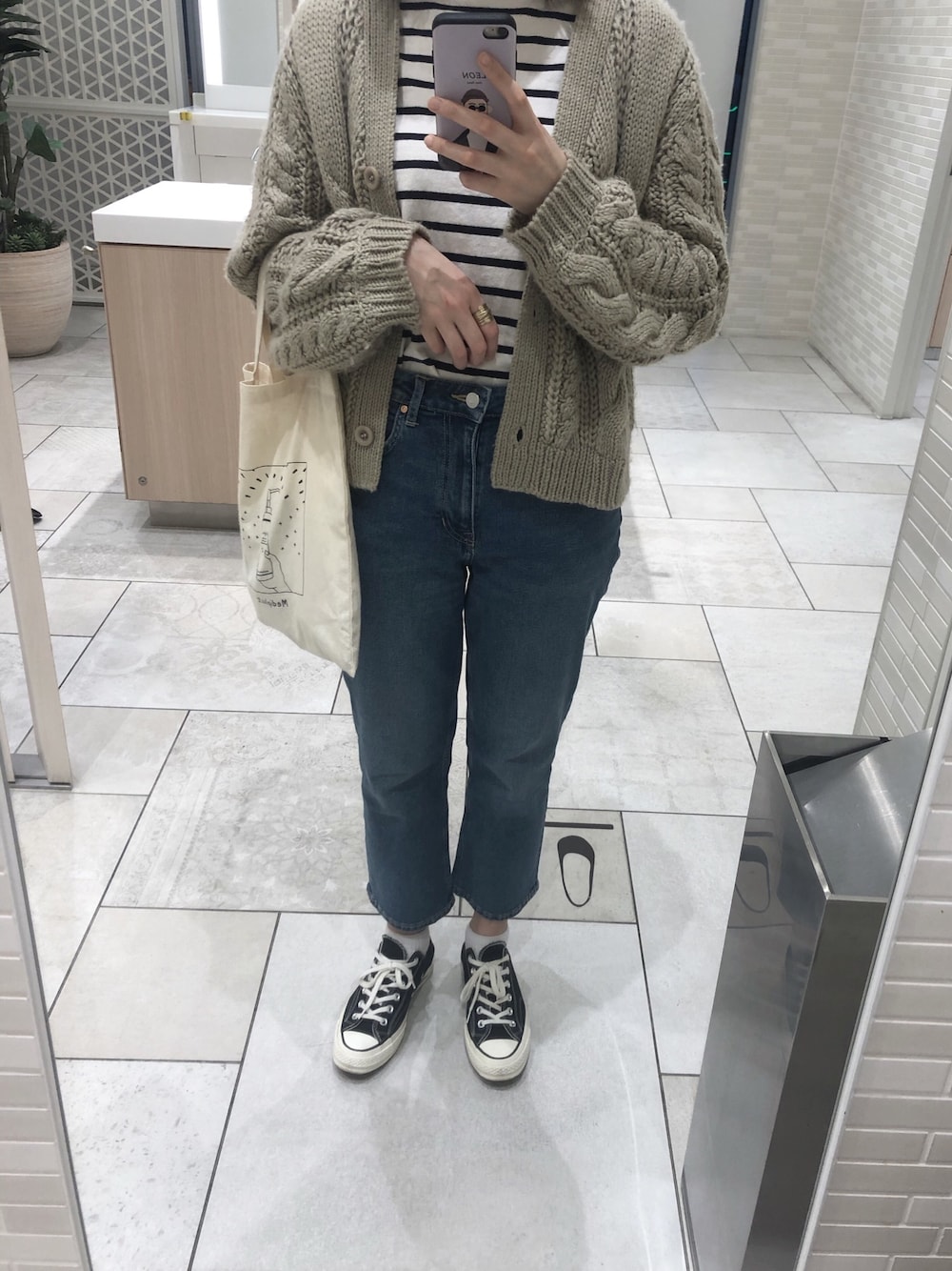 ベージュ系のカーディガン/ボレロ、ブラック系のスニーカーを着用したレディースの春コーディネートの1枚目の写真