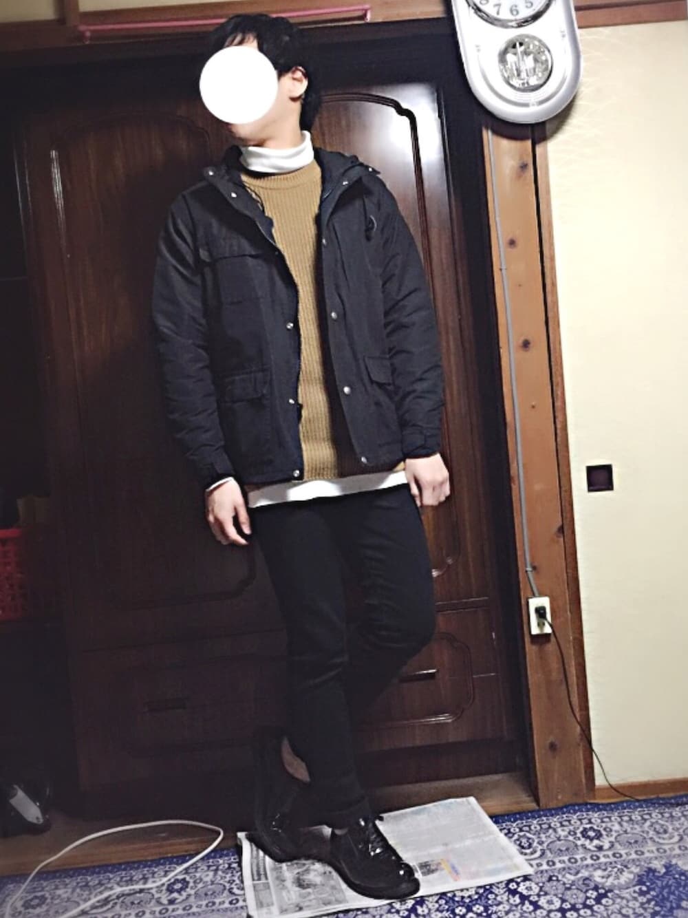 ブラック系のマウンテンパーカー、ベージュ系のニット/セーター、ホワイト系のTシャツ/カットソーを着用したメンズの冬コーディネートの1枚目の写真