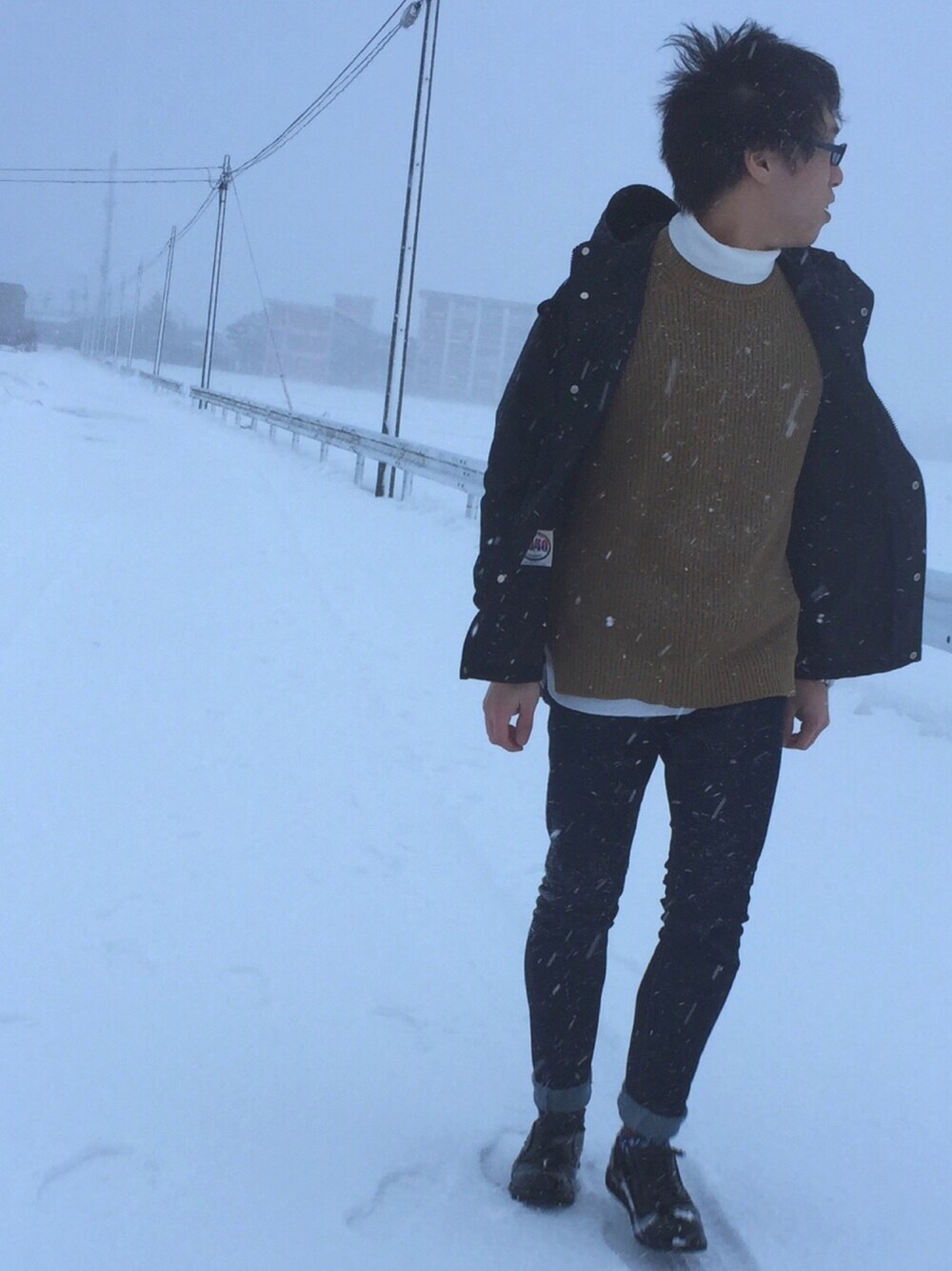 ブラック系のマウンテンパーカー、ベージュ系のニット/セーター、ホワイト系のTシャツ/カットソーを着用したメンズの冬コーディネートの1枚目の写真