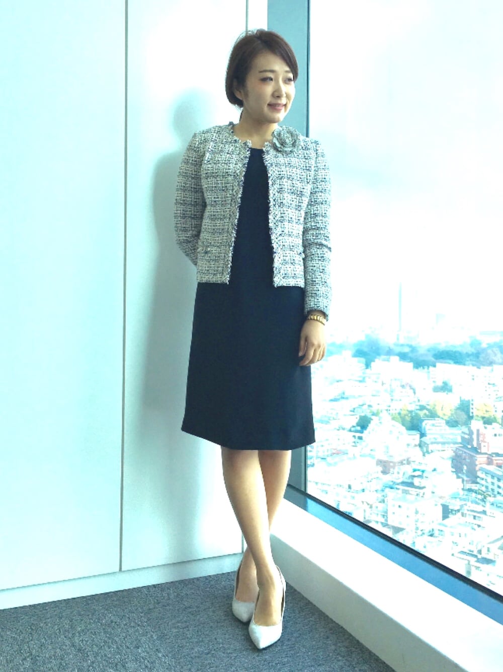 ベージュ系のノーカラージャケット、ブルー系のワンピース、ベージュ系のブローチ/コサージュを着用したレディースの冬コーディネートの1枚目の写真