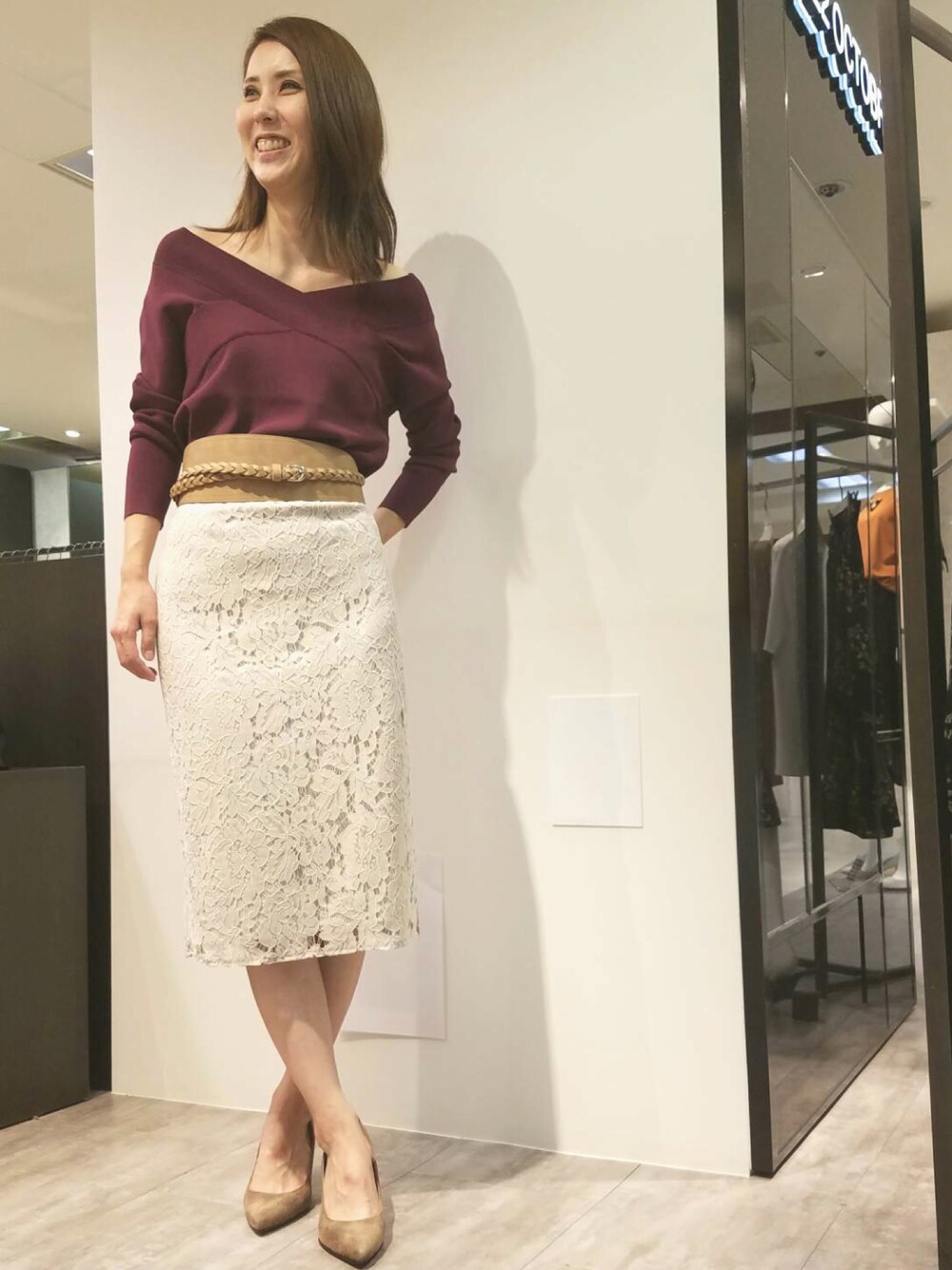 レッド系のニット/セーター、グレー系のスカート、ベージュ系のベルトを着用したレディースの夏コーディネートの1枚目の写真