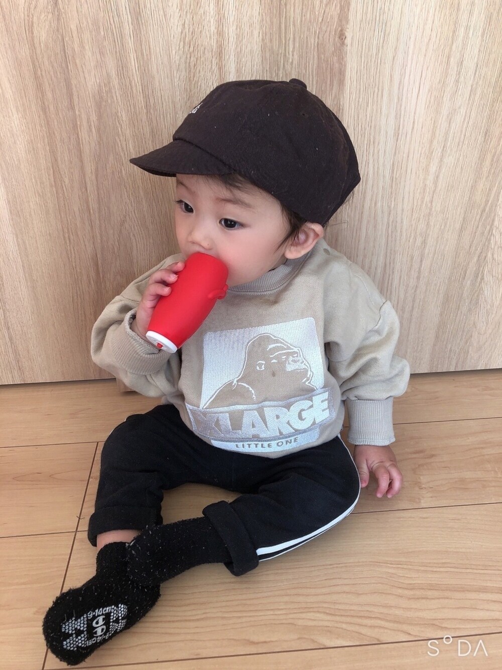 ベージュ系のスウェット、ブラック系のその他パンツ、ブラウン系のキャップを着用したキッズの冬コーディネートの1枚目の写真