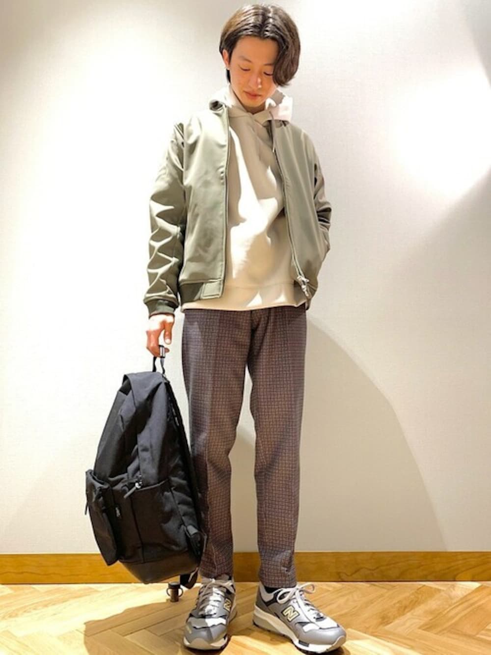 ブラック系のバックパック/リュック、グレー系のパーカー、グレー系のスラックスを着用したメンズの冬コーディネートの1枚目の写真