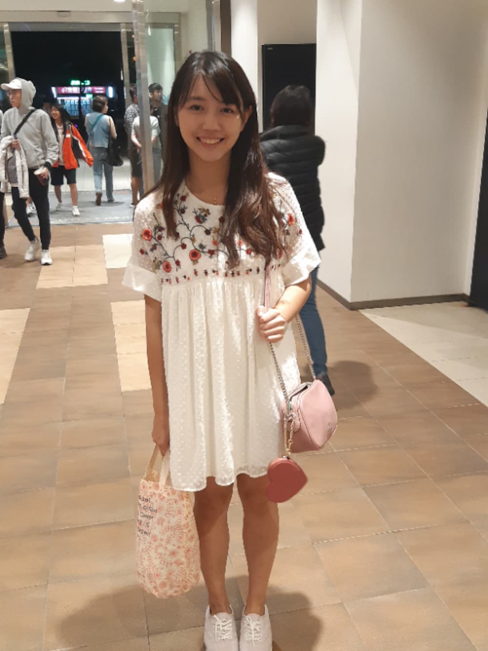 ホワイト系のワンピース、ピンク系のハンドバッグ、ピンク系のウォレットチェーンを着用したレディースの秋コーディネートの1枚目の写真