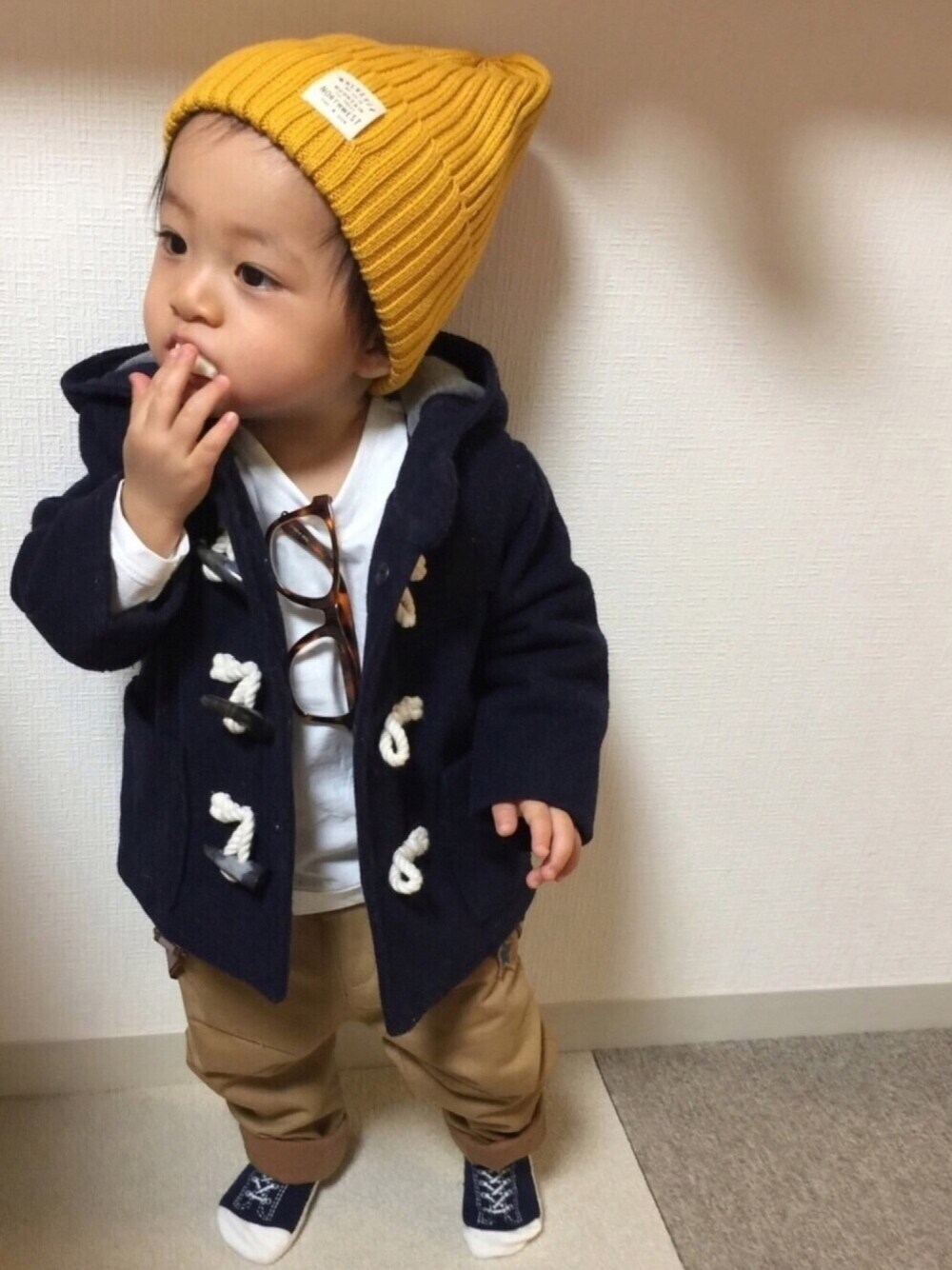 ベージュ系のパンツ、ブルー系のダッフルコート、ホワイト系のTシャツ/カットソーを着用したキッズの冬コーディネートの1枚目の写真