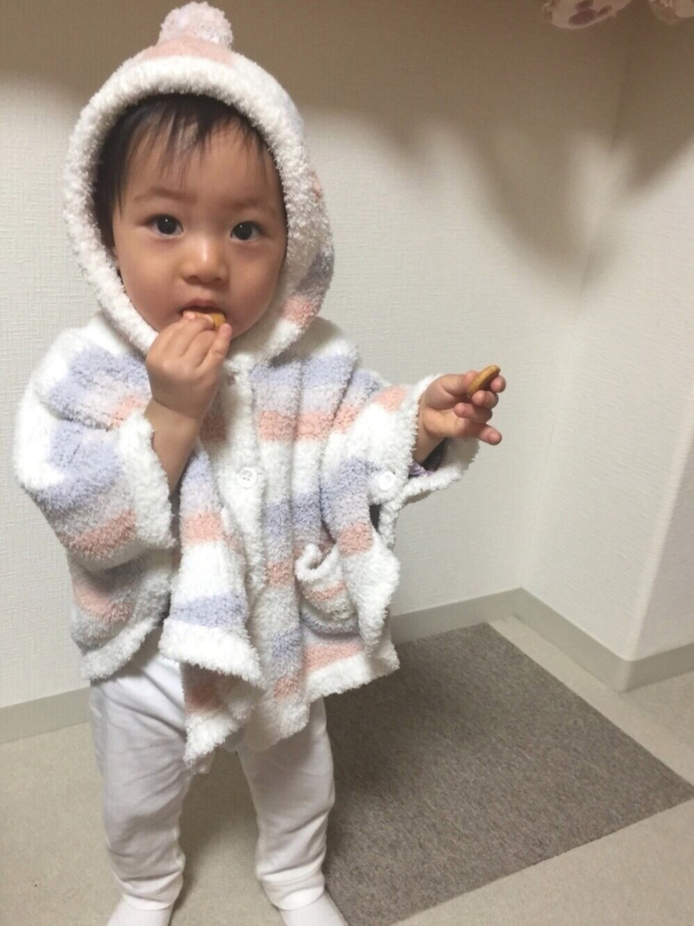 ホワイト系のポンチョ、ホワイト系のパンツ、ホワイト系のソックス/靴下を着用したキッズの冬コーディネートの1枚目の写真