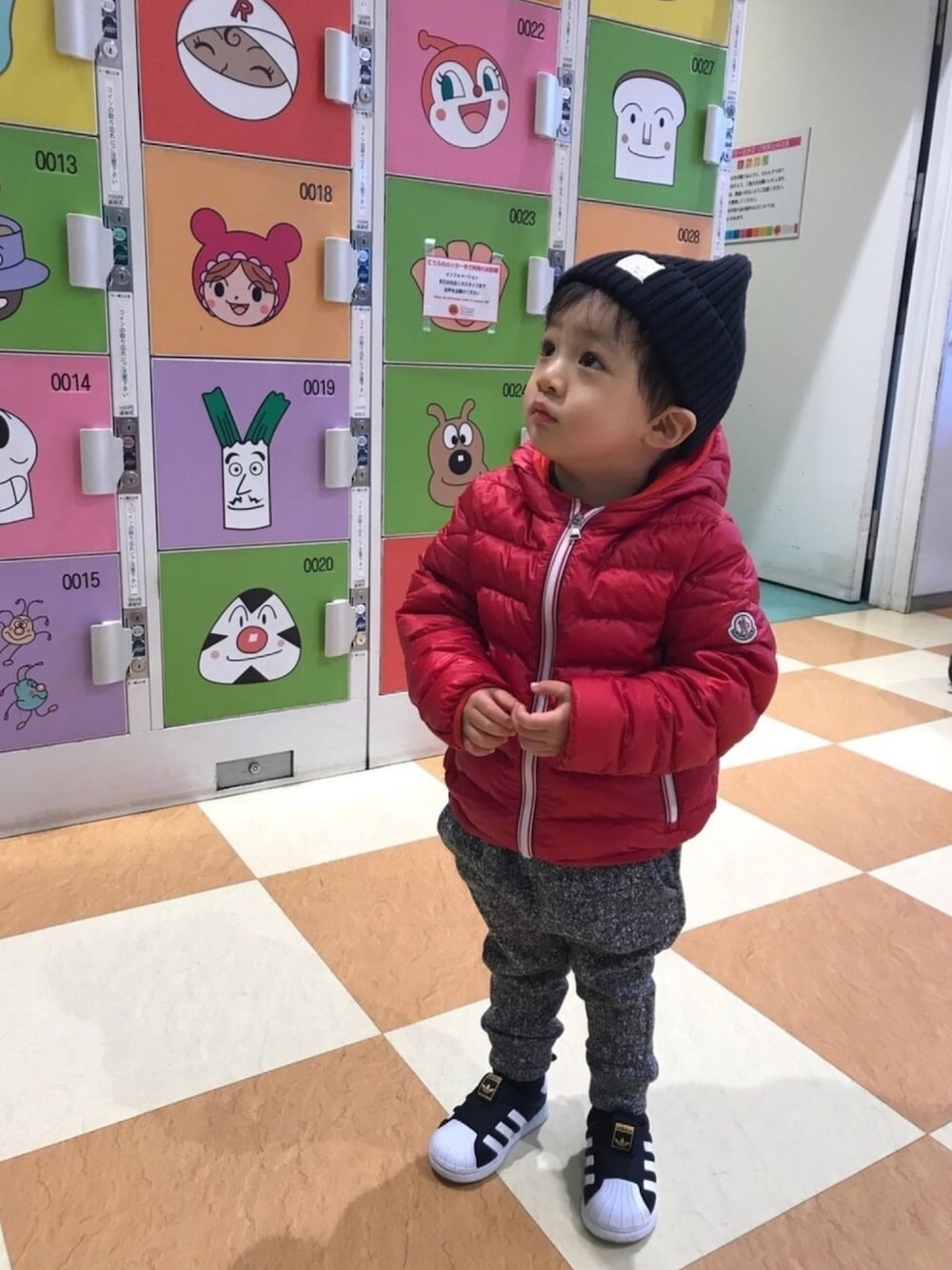 レッド系のダウンジャケット/コート、ブラック系のその他パンツ、ブラック系のスニーカーを着用したキッズの冬コーディネートの1枚目の写真