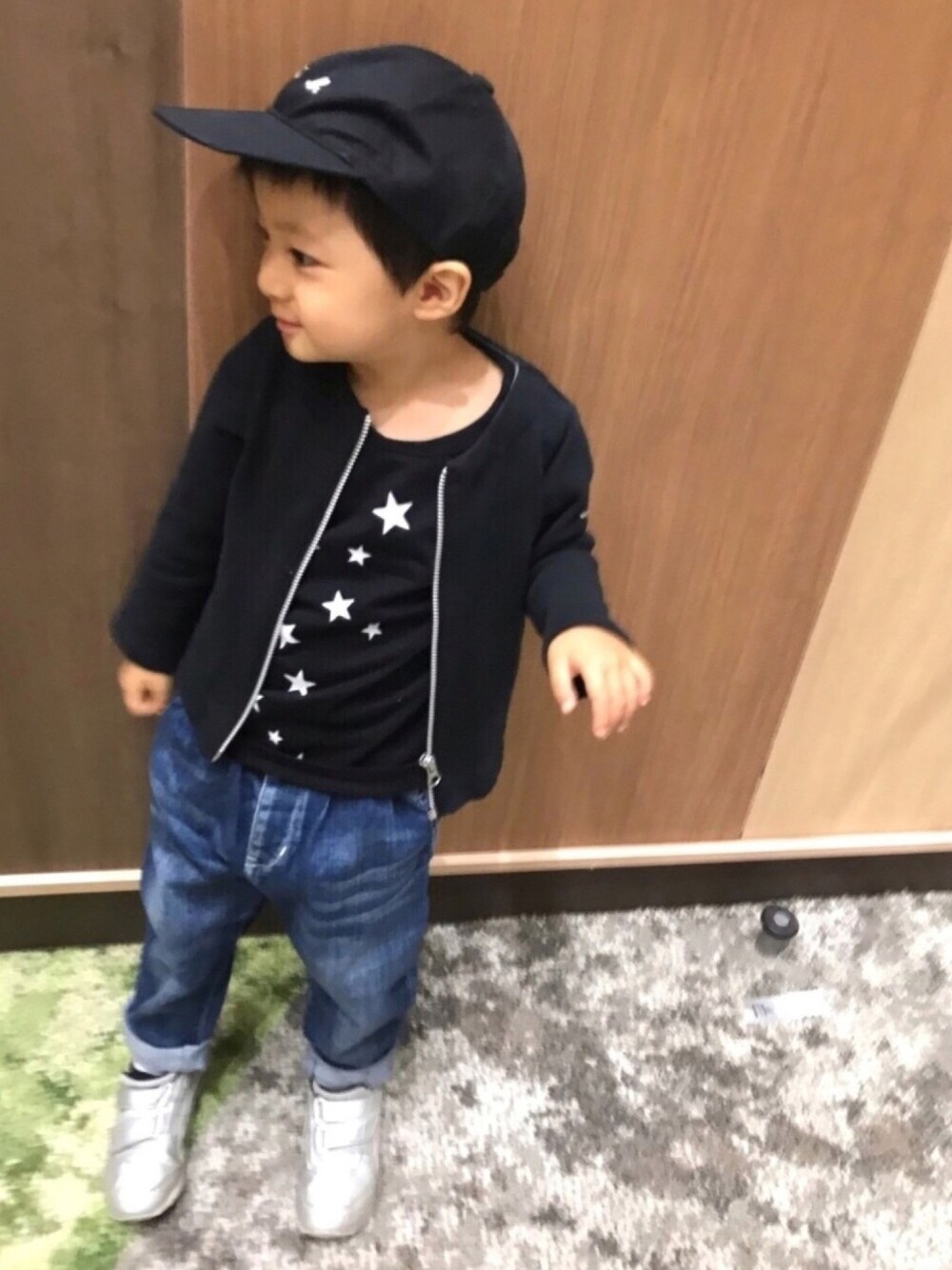 ブラック系のノーカラージャケット、ブラック系のTシャツ/カットソー、ブルー系のデニムパンツを着用したキッズの秋コーディネートの1枚目の写真