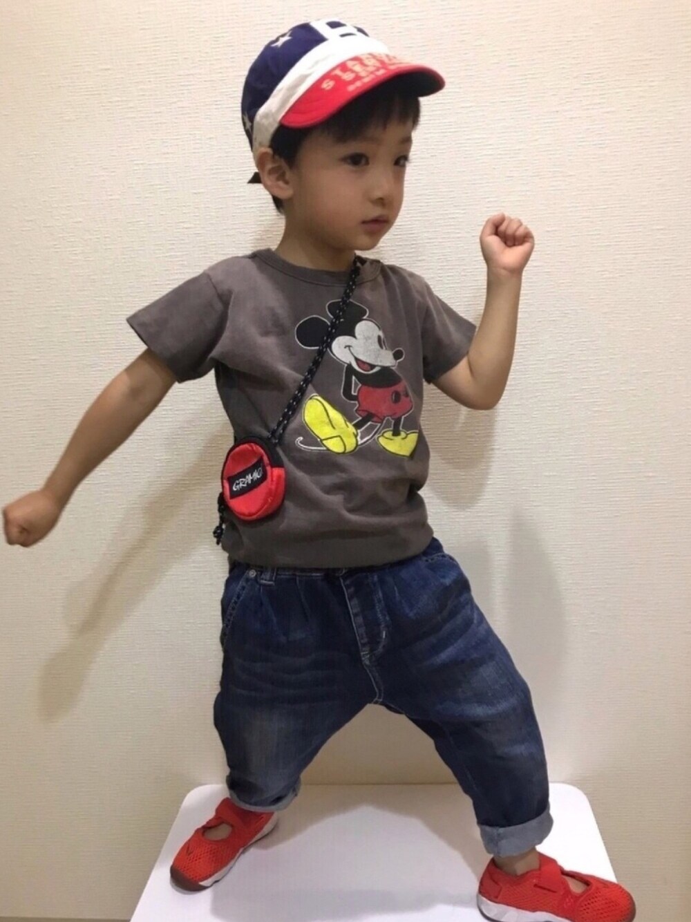 グレー系のTシャツ/カットソー、ブルー系のデニムパンツ、レッド系のスニーカーを着用したキッズの夏コーディネートの1枚目の写真