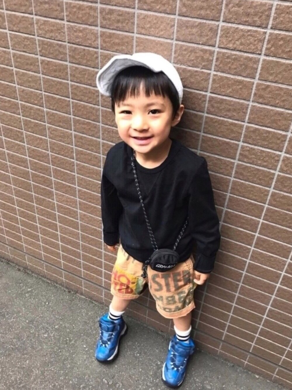 ブラック系のTシャツ/カットソー、ベージュ系のパンツ、ブルー系のスニーカーを着用したキッズの夏コーディネートの1枚目の写真