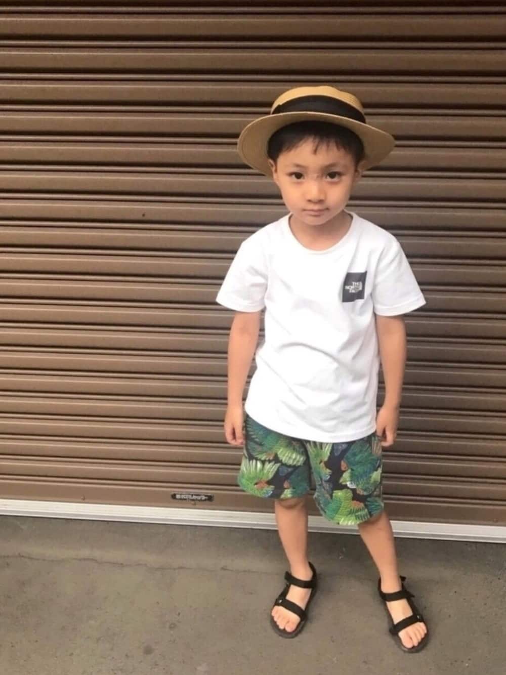 ホワイト系のTシャツ/カットソー、ブラック系のパンツ、ブラック系のサンダルを着用したキッズの夏コーディネートの1枚目の写真
