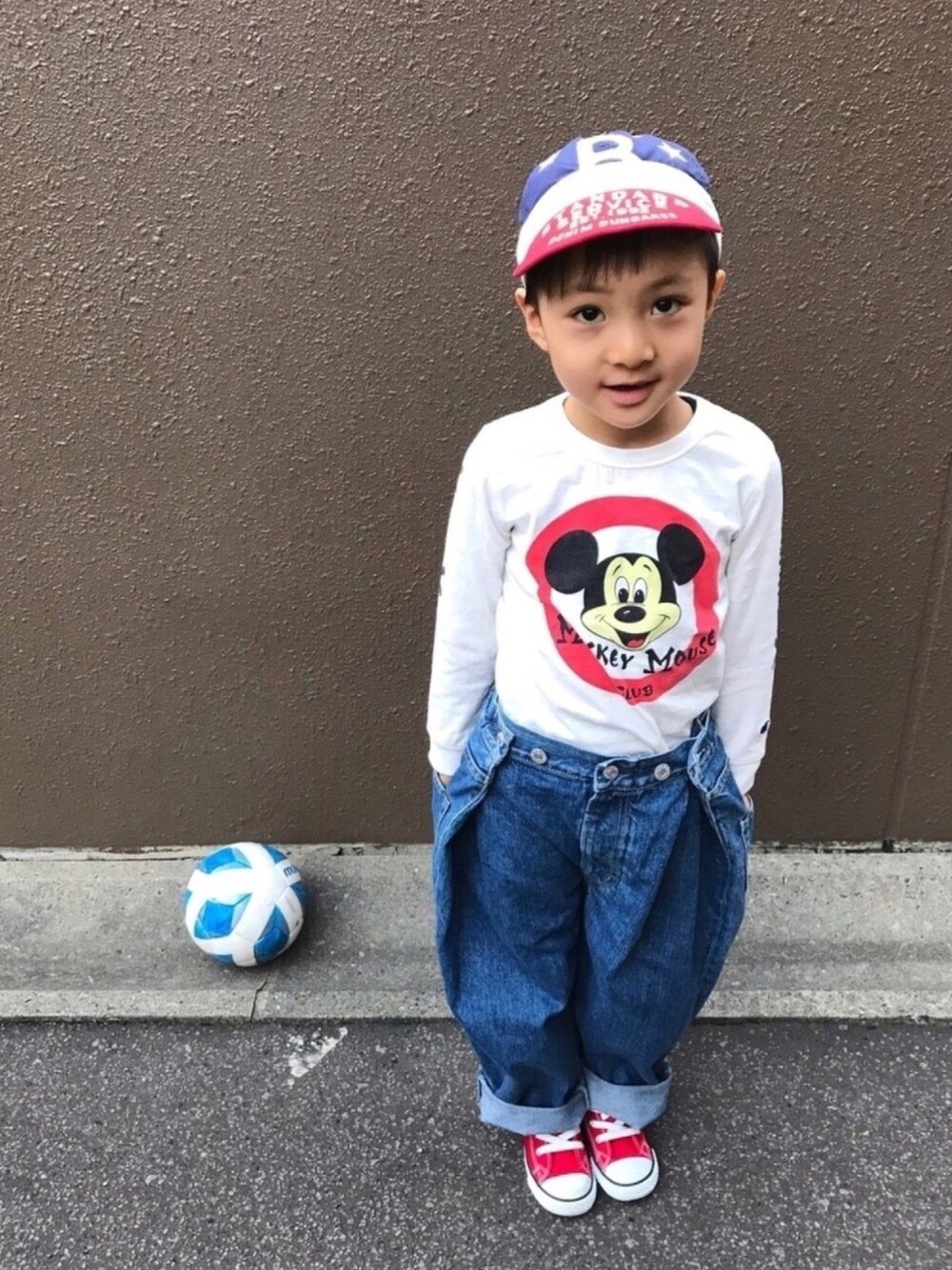 ホワイト系のTシャツ/カットソー、ブルー系のデニムパンツ、レッド系のスニーカーを着用したキッズの秋コーディネートの1枚目の写真