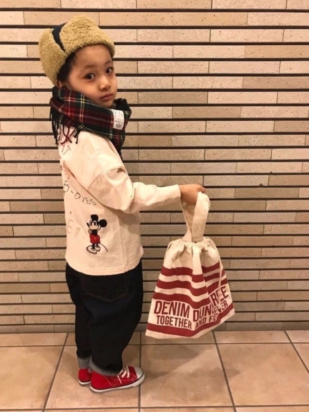 ホワイト系のTシャツ/カットソー、ブルー系のデニムパンツ、レッド系のスニーカーを着用したキッズの冬コーディネートの1枚目の写真