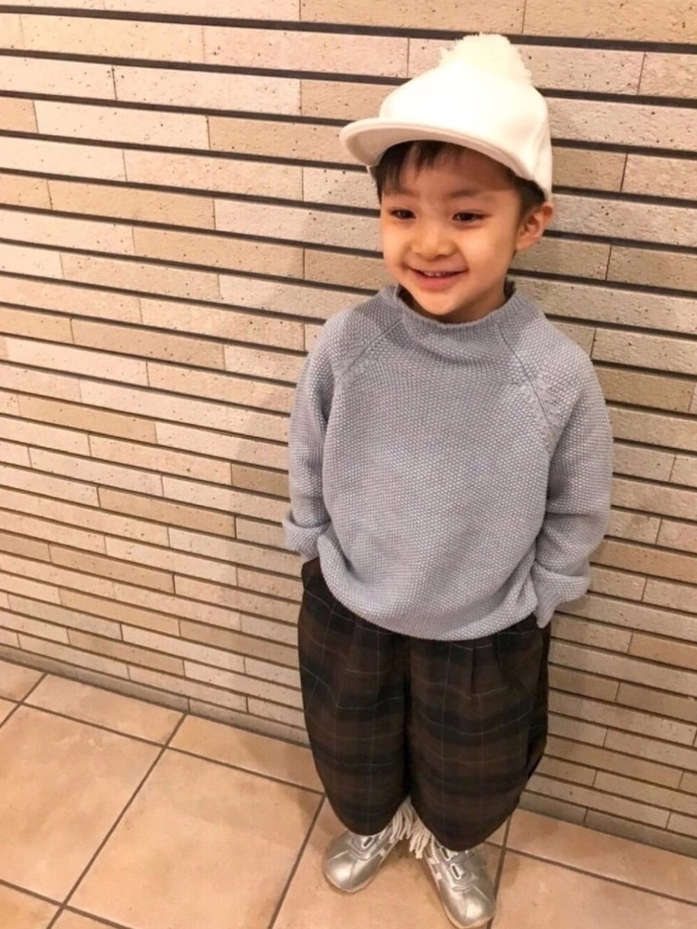 ブルー系のニット/セーター、ブラウン系のその他パンツ、シルバー系のスニーカーを着用したキッズの冬コーディネートの1枚目の写真