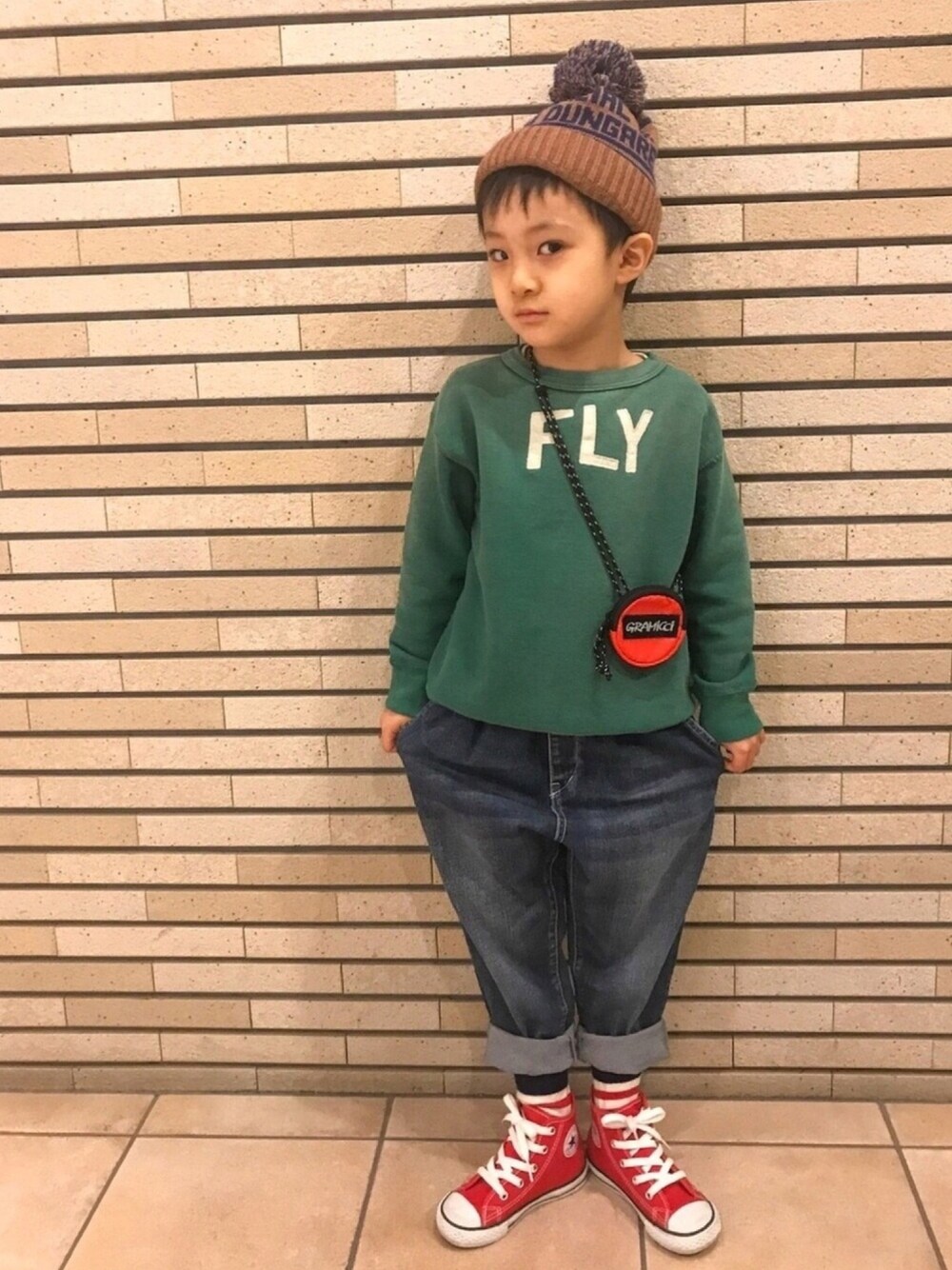 ホワイト系のスウェット、ブルー系のデニムパンツ、レッド系のスニーカーを着用したキッズの冬コーディネートの1枚目の写真