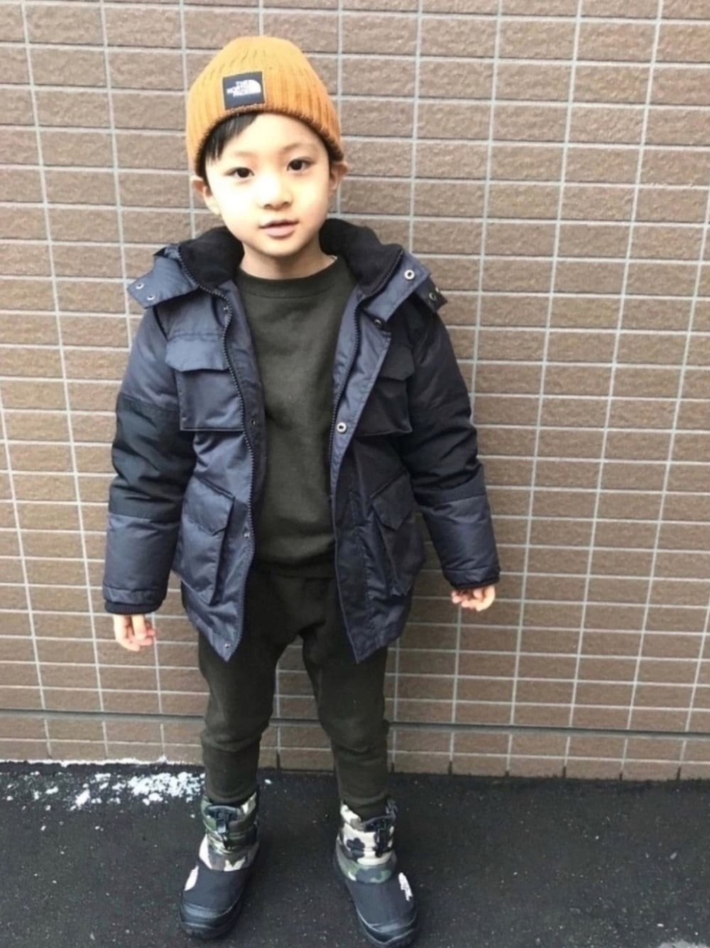 ブラック系のダウンジャケット/コート、グリーン系のスウェット、グリーン系のその他パンツを着用したキッズの冬コーディネートの1枚目の写真