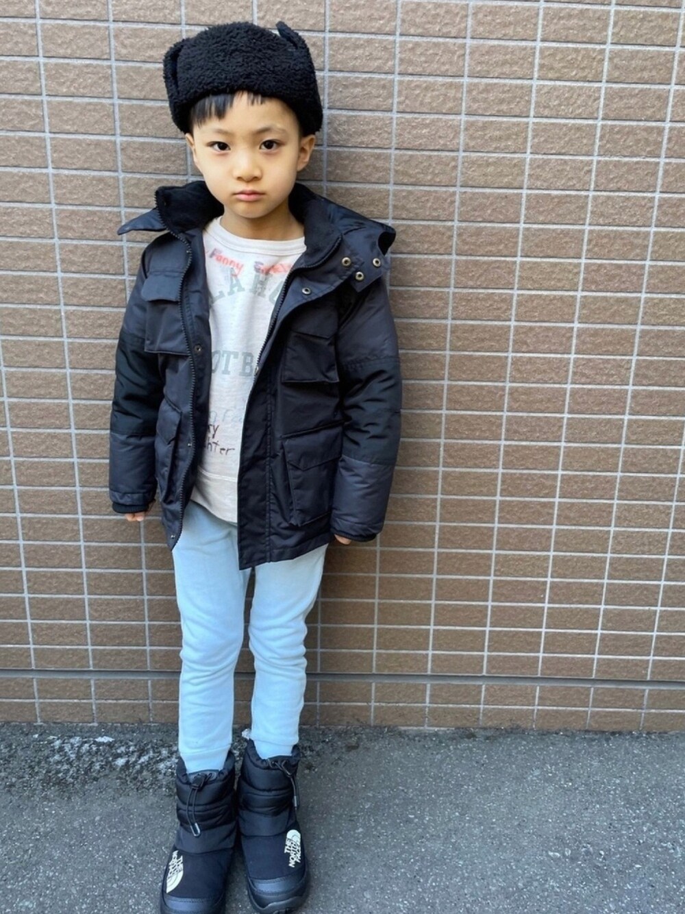 ブラック系のダウンジャケット/コート、ホワイト系のスウェット、ブルー系のその他パンツを着用したキッズの春コーディネートの1枚目の写真