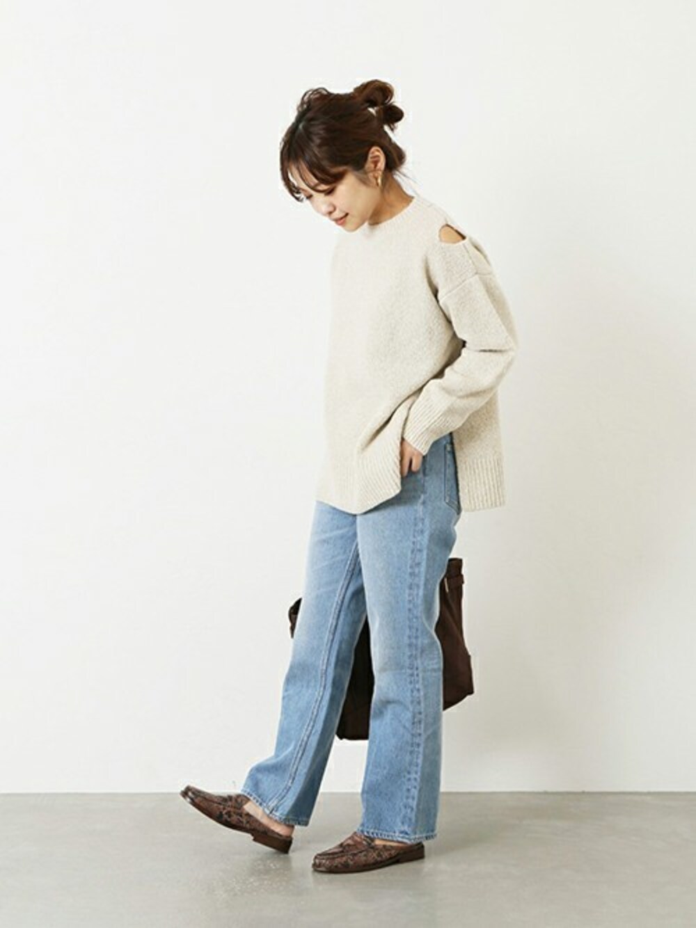 ホワイト系のニット/セーター、ブルー系のデニムパンツ、ブラウン系のショルダーバッグを着用したレディースの冬コーディネートの1枚目の写真