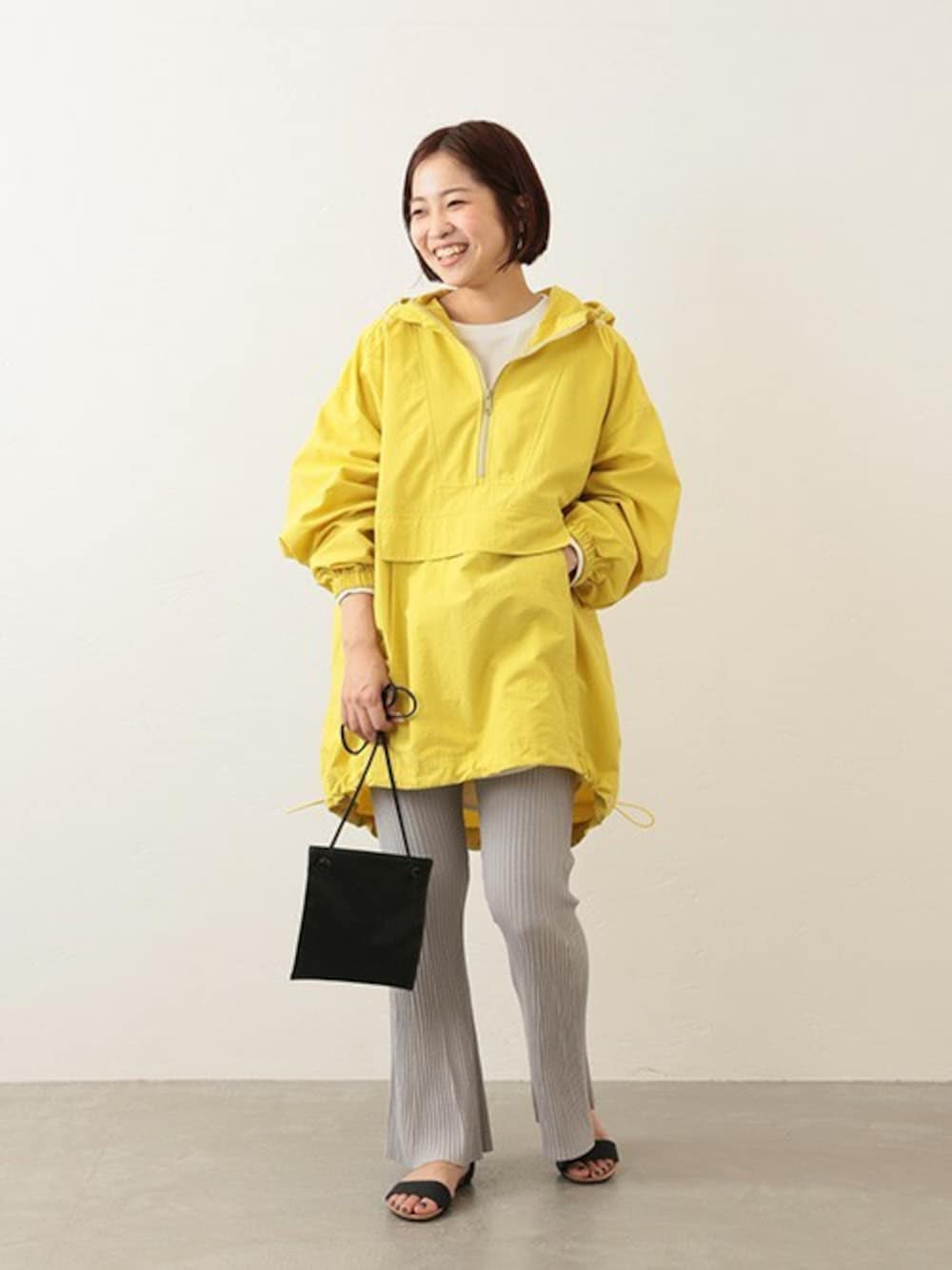 オレンジ系のマウンテンパーカー、ブラック系のショルダーバッグ、ホワイト系のTシャツ/カットソーを着用したレディースの冬コーディネートの1枚目の写真