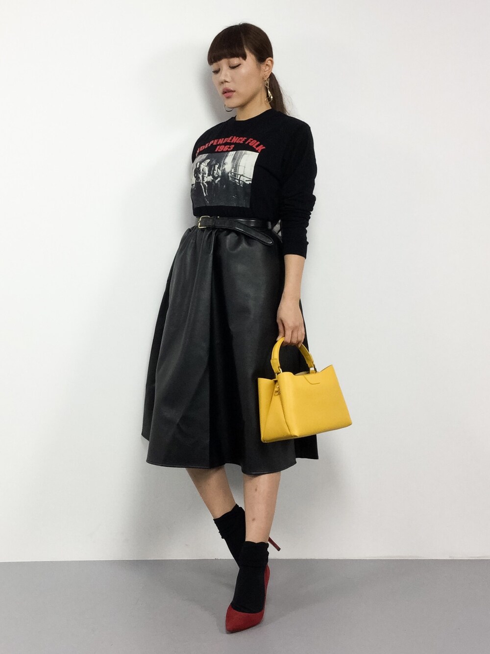「カジュアル、イエロー、レザースカート、大人カジュアル、ootd、ロックT、ロックテイスト」｜「AZUL by moussyのフォトプリントロンT（Tシャツ/カットソー、ブラック系）」を使った、黒田デビーさん（レディース・165cm）の冬コーディネートの1枚目の写真