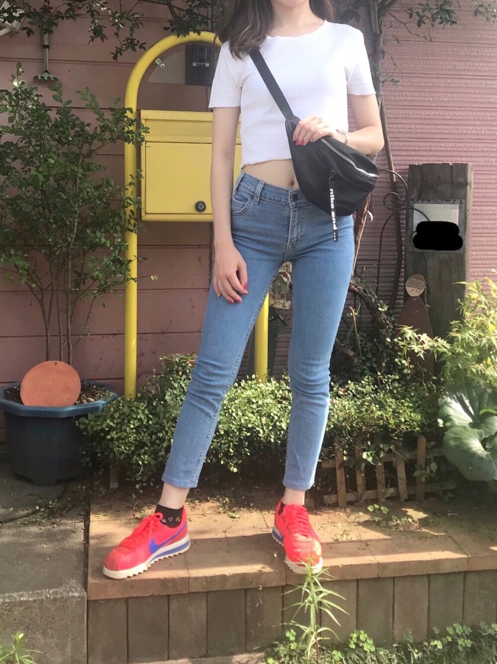 レッド系のスニーカー、ブルー系のデニムパンツ、ホワイト系のTシャツ/カットソーを着用したレディースの夏コーディネートの1枚目の写真