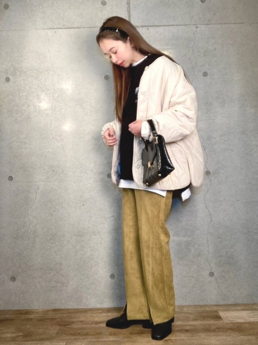 ホワイト系のブルゾン、ブラック系のTシャツ/カットソー、ブラック系のショルダーバッグを着用したレディースの冬コーディネートの1枚目の写真