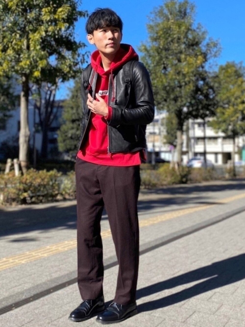ブラック系のドレスシューズ、ブラウン系のパンツ、レッド系のパーカーを着用したメンズの冬コーディネートの1枚目の写真
