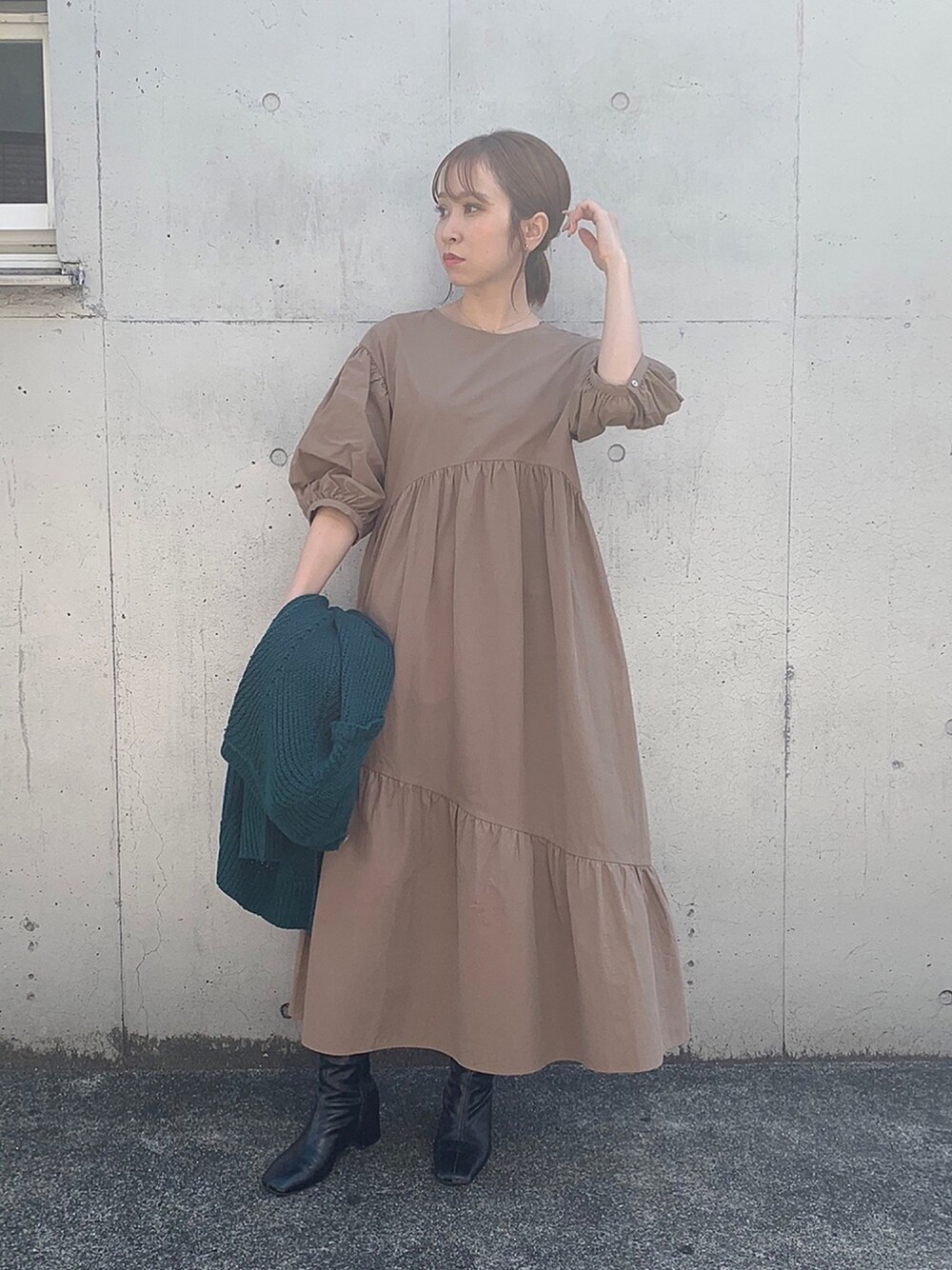 ブラウン系のワンピース、グリーン系のニット/セーター、ブラック系のブーツを着用したレディースの秋コーディネートの1枚目の写真