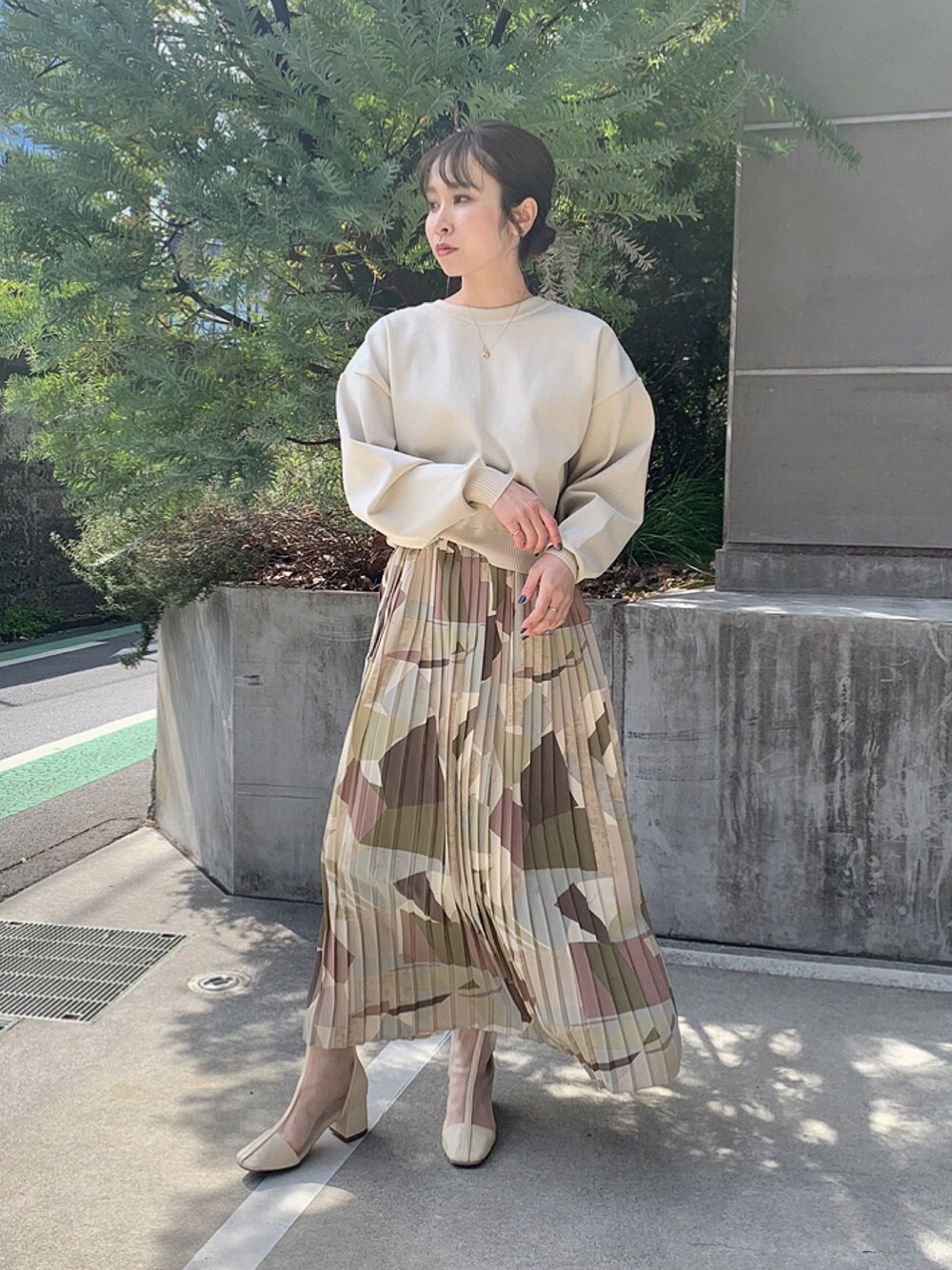 ホワイト系のカーディガン/ボレロ、ピンク系のスカート、ブラック系のブーツを着用したレディースの冬コーディネートの1枚目の写真