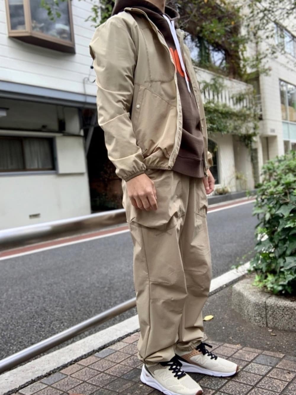 ブラウン系のパーカー、ベージュ系のブルゾン、ベージュ系のその他パンツを着用したメンズの秋コーディネートの1枚目の写真