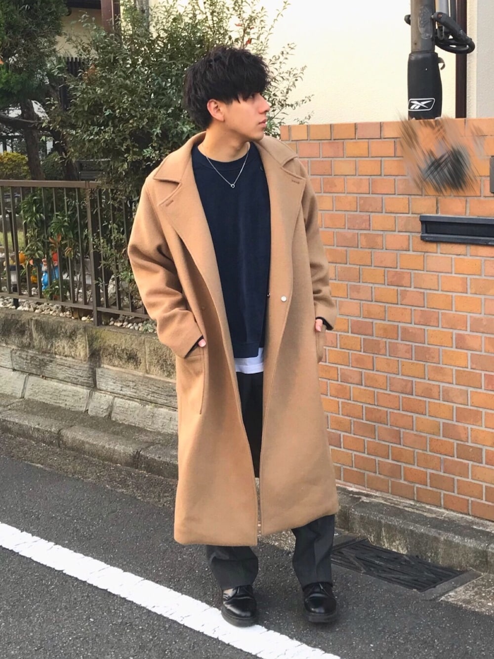 イエロー系のチェスターコート、ブルー系のスウェット、ホワイト系のTシャツ/カットソーを着用したメンズの秋コーディネートの1枚目の写真