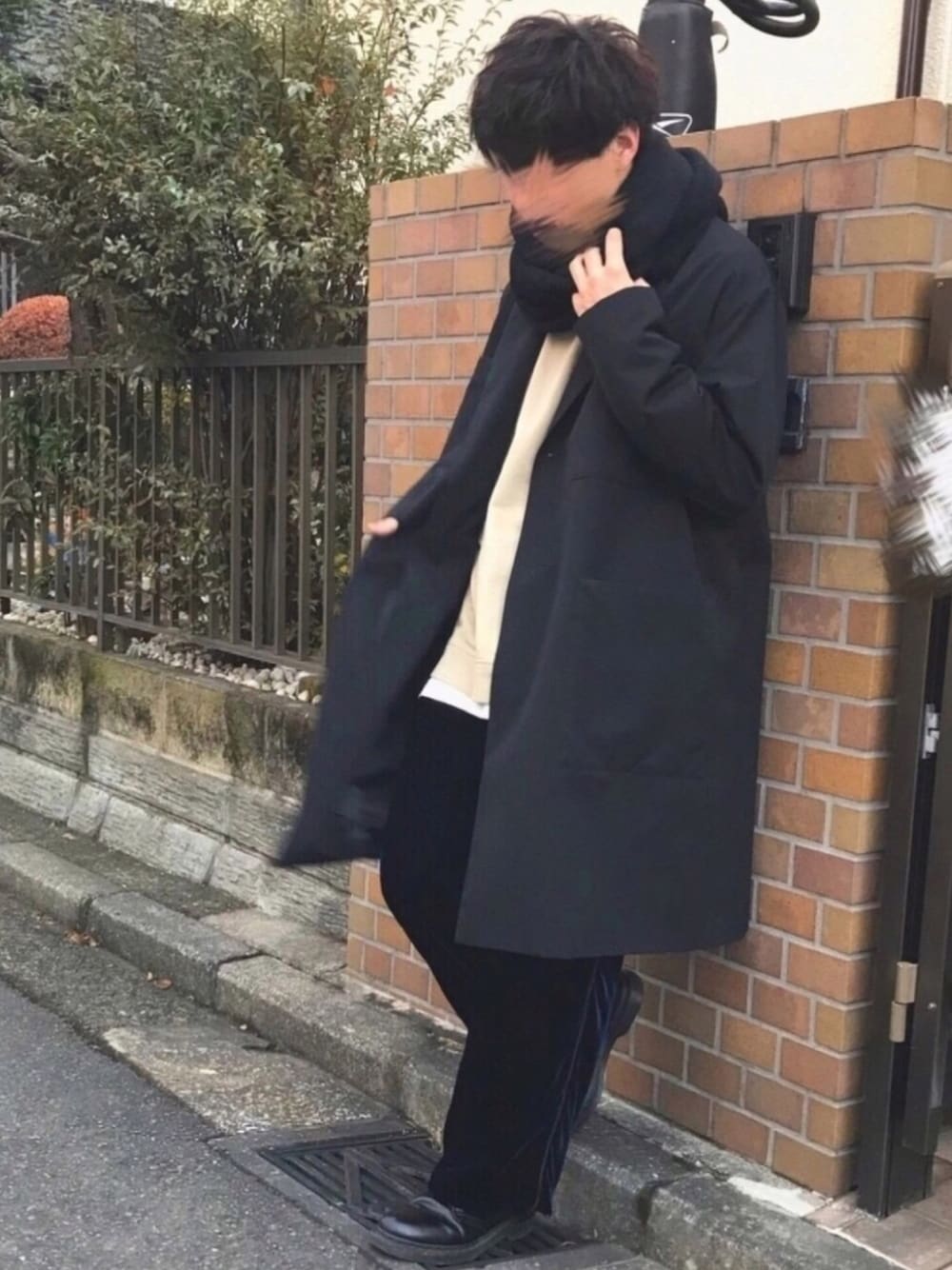 ブラック系のチェスターコート、ベージュ系のスウェット、ホワイト系のTシャツ/カットソーを着用したメンズの秋コーディネートの1枚目の写真