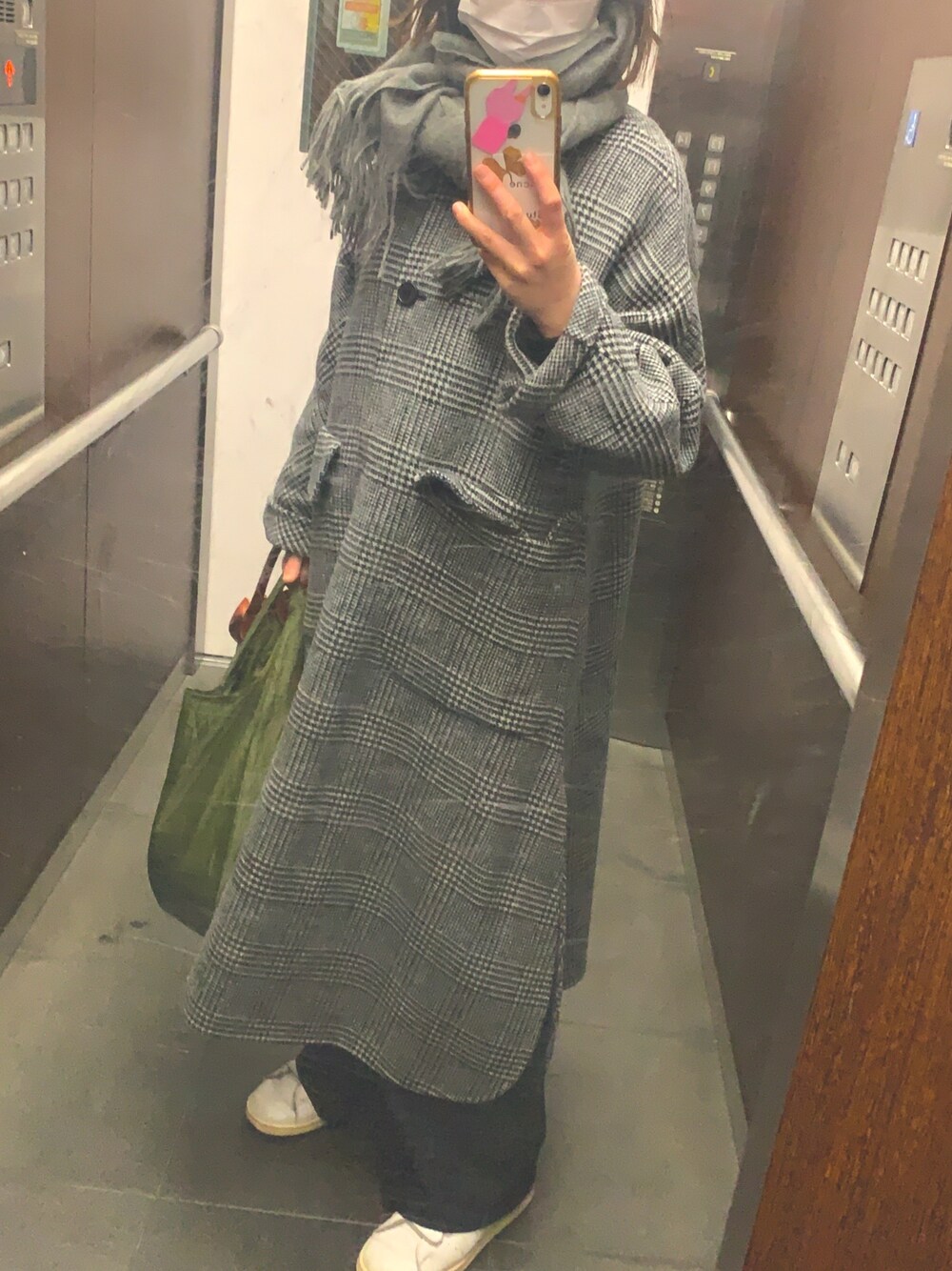 グレー系のノーカラーコート、グレー系のマフラーを着用したレディースの冬コーディネートの1枚目の写真