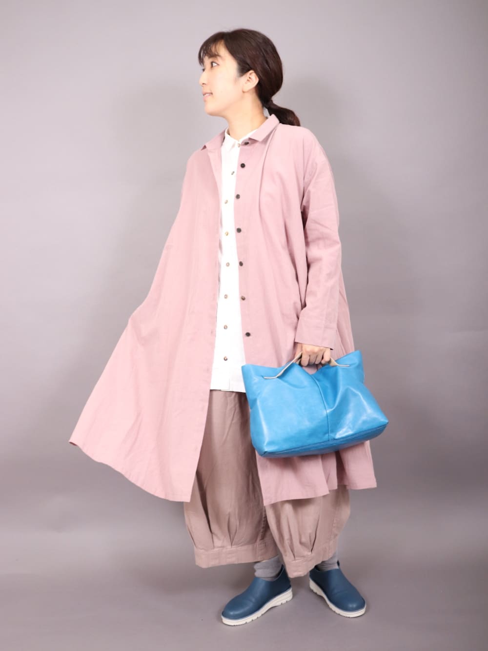 ピンク系のワンピース/ドレス、ベージュ系のパンツ、ブルー系のバッグを着用したレディースの秋コーディネートの1枚目の写真