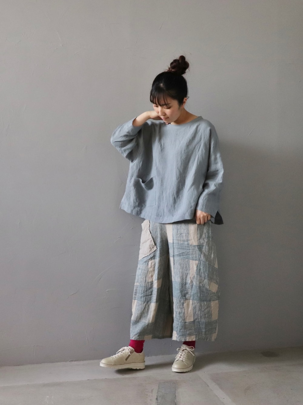 シルバー系のトップス、ブルー系のパンツ、ホワイト系のシューズを着用したレディースの春コーディネートの1枚目の写真