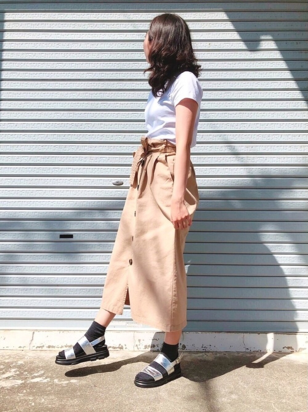 ホワイト系のTシャツ/カットソー、ベージュ系のスカート、シルバー系のサンダルを着用したレディースの春コーディネートの1枚目の写真
