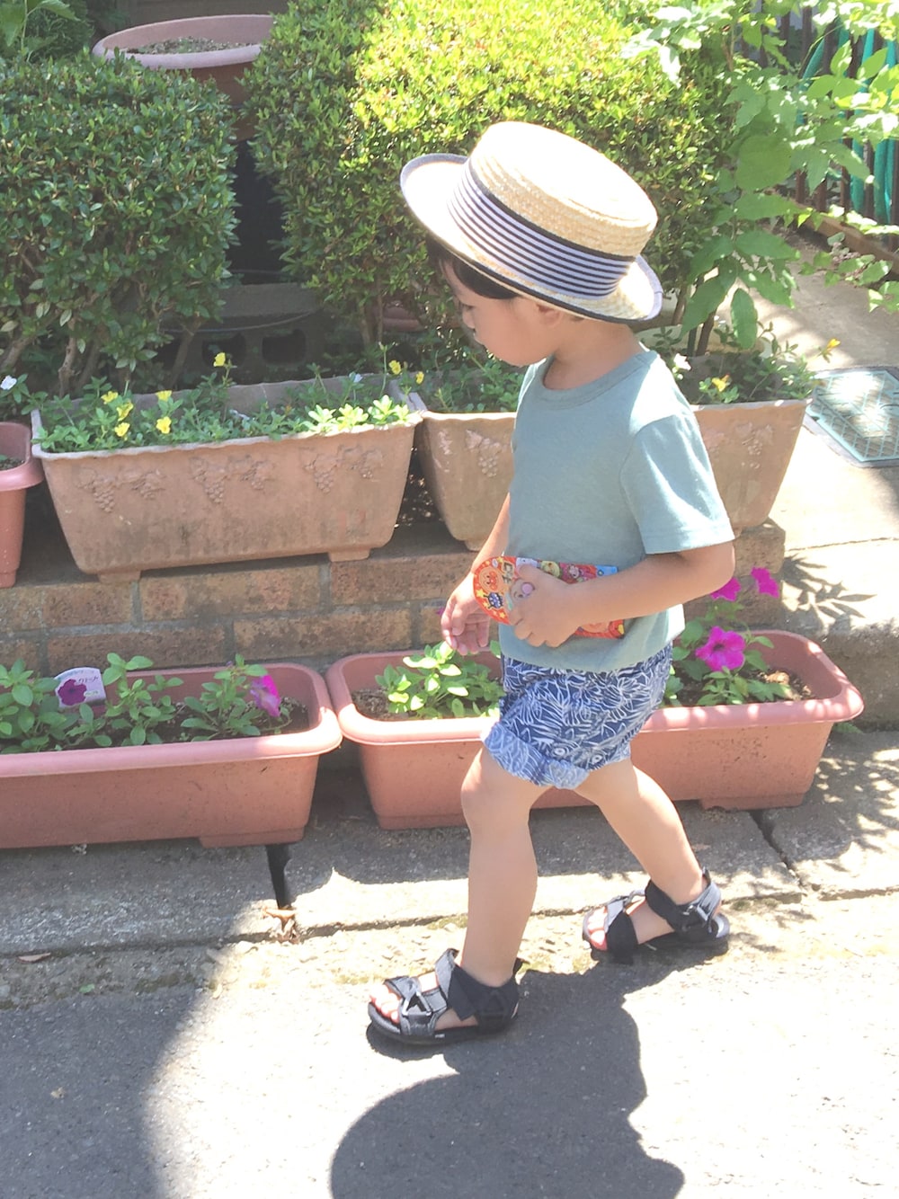 グリーン系のTシャツ/カットソー、ブルー系のパンツ、ブラック系のサンダルを着用したキッズの夏コーディネートの1枚目の写真