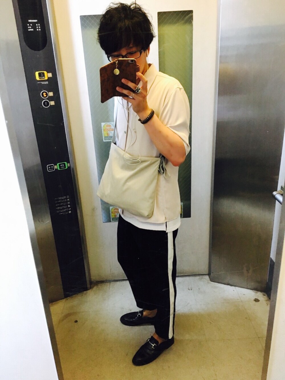 グレー系のショルダーバッグ、シルバー系のリング、レッド系のリングを着用したメンズの春コーディネートの1枚目の写真