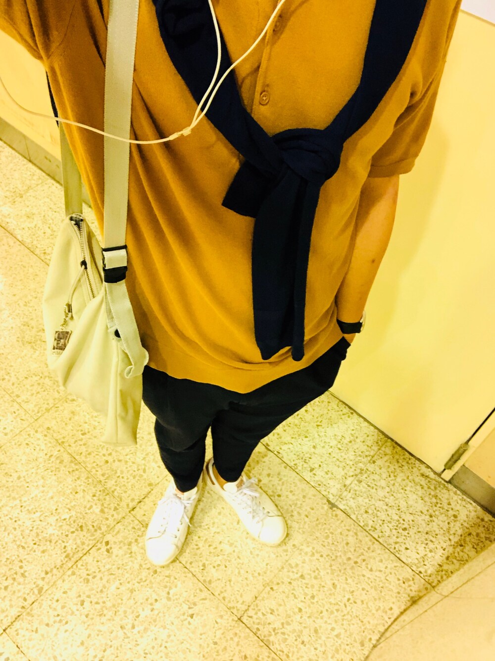 ベージュ系のポロシャツ、ピンク系のスニーカー、グレー系のショルダーバッグを着用したメンズの夏コーディネートの1枚目の写真