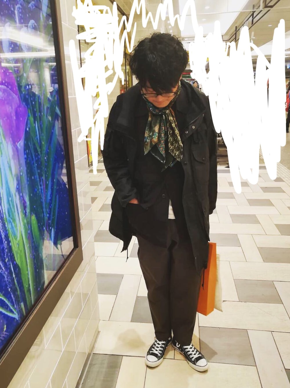 ブラック系のジャケット/アウター、グレー系のチノパンツ、グリーン系のマフラーを着用したメンズの春コーディネートの1枚目の写真