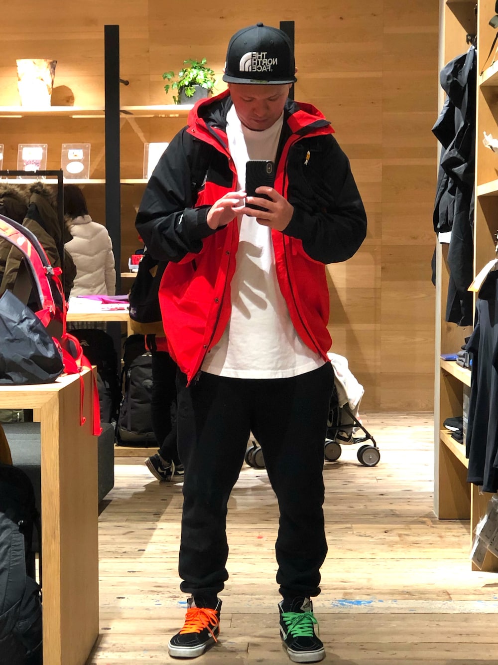 ホワイト系のTシャツ/カットソー、レッド系のマウンテンパーカー、ブラック系のその他パンツを着用したメンズの冬コーディネートの1枚目の写真