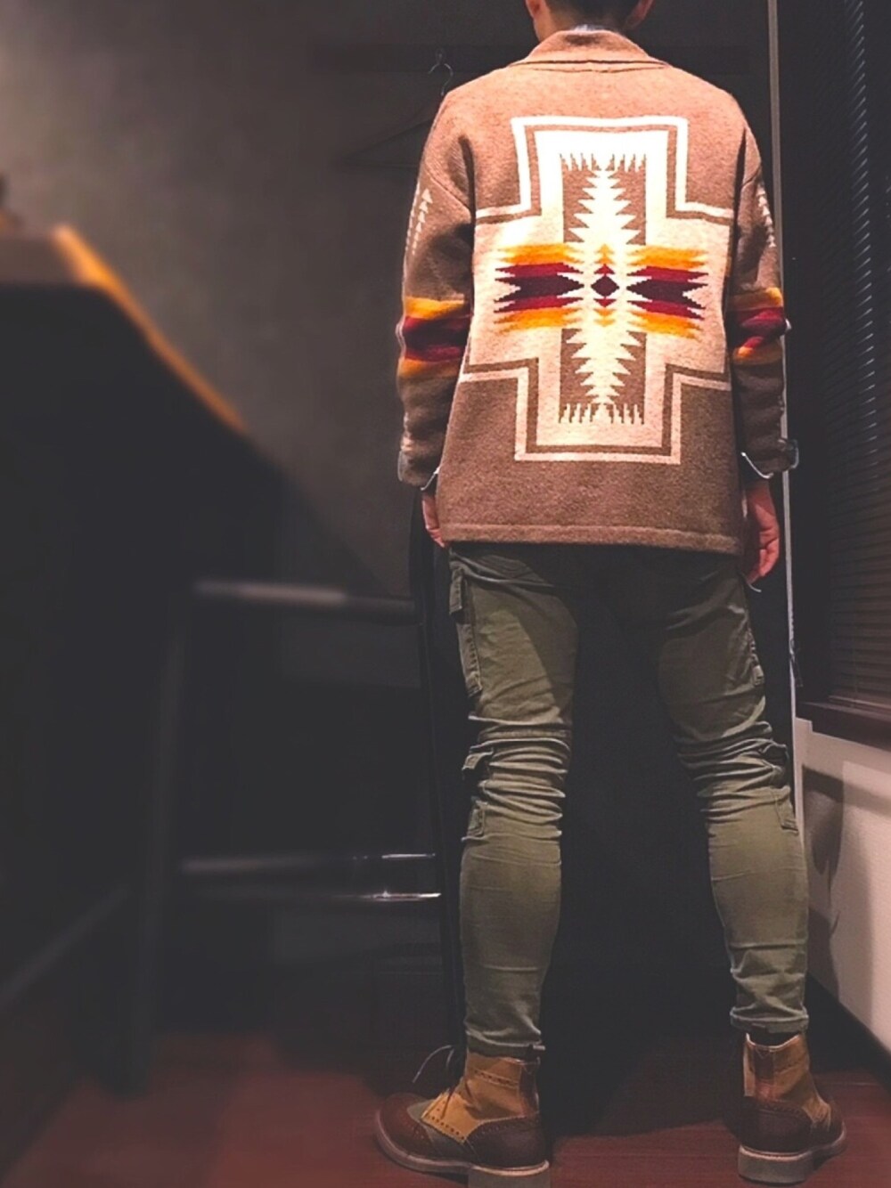 ブラウン系のカーディガン/ボレロ、グリーン系のカーゴパンツ、ブラウン系のブーツを着用したメンズの冬コーディネートの1枚目の写真