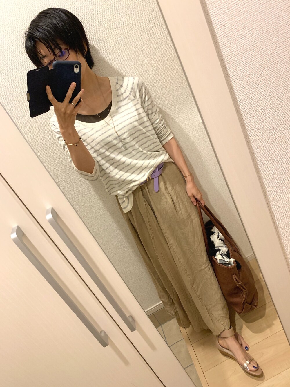 ホワイト系のニット/セーター、ベージュ系のスカート、ピンク系のサンダルを着用したレディースの春コーディネートの1枚目の写真
