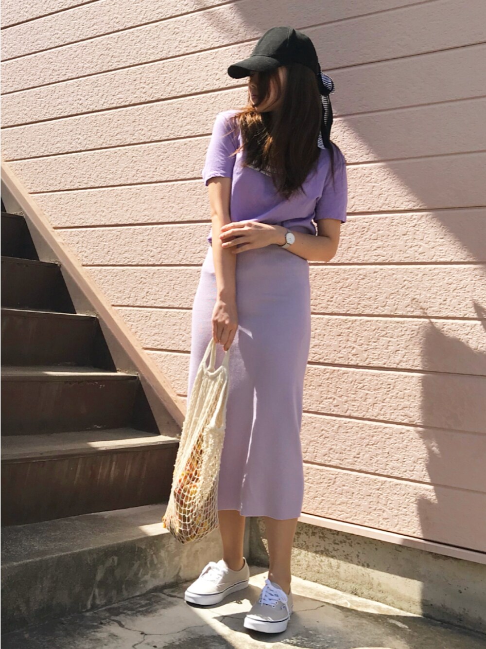 パープル系のTシャツ/カットソー、パープル系のスカート、ベージュ系のスニーカーを着用したレディースの春コーディネートの1枚目の写真